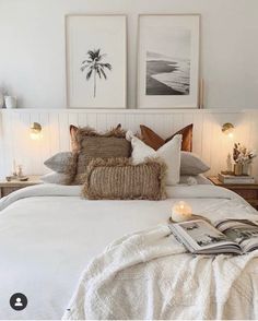 a bed with white sheets and pillows in a bedroom next to two pictures on the wall