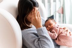 a woman is holding her baby in her lap while she holds it up to her face