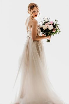 a woman in a wedding dress holding a bouquet