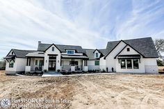 a large white house sitting on top of a dirt field