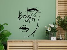 a wall decal with the words brown artist on it in black ink next to a plant