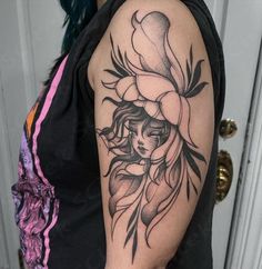 a woman's arm with a tattoo on it and flowers in her hair is shown