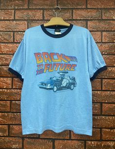 "Vintage 90s Back To The Future American Legendary Sci Fi 1985 Movie T Shirt / Science Fiction / Cult Movie / Vintage Movie T Shirt Size L Condition : Good Used Size on tag : M fits L Colour : Blue Brand : Thunder Creek Measurement : Armpit to armpit -21\" Length - 26.5\" Material : Old Cotton Made In: Usa THE SHIPPING POLICY 1. Item will be shipped in 3-5days after payment. The shipping cost $20 is via DHL Express Service. It will take 3-5days working day or more for delivery, depends on your c Movie Tshirt Designs, Film T Shirt, Vintage Blue Tops For Fan Merchandise, Blue Crew Neck Top With Vintage Print, 90s Shirts Vintage, Aesthetic Clothes 90s, 90s T Shirts, 90s Graphic Tees Vintage, Back To The Future Shirt