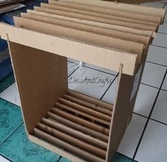 an open cardboard box sitting on top of a tiled floor next to blue and white tiles