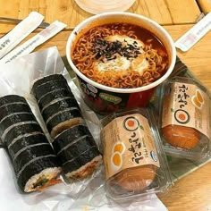 an assortment of ramen and soup items on a wooden table with chopsticks