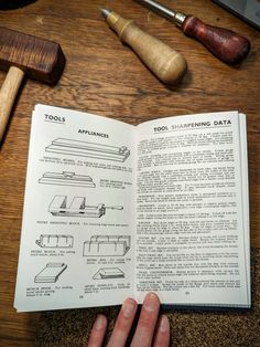 an open book with instructions on how to use a sewing machine and tools sitting next to it