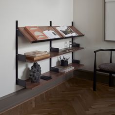 a book shelf with two books on it and a chair in the corner next to it