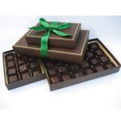 two chocolate boxes with green ribbon on them