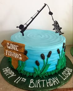 a fishing themed birthday cake with fish on the top and gone fishing sign above it