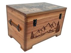 a wooden box with mountains and trees on it