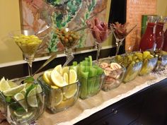 a table topped with glasses filled with different types of fruit and vegtables