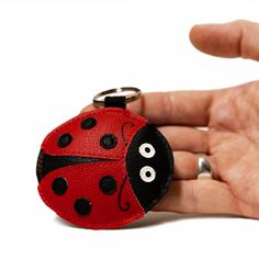 a ladybug keychain in the palm of someone's hand