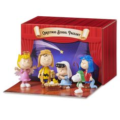 the peanuts gang figurines are on display in front of a red stage curtain