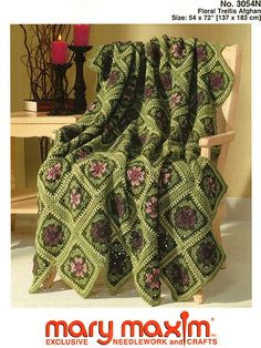 a green crocheted blanket sitting on top of a chair next to a table