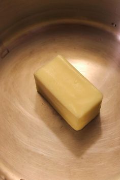 a piece of butter sitting on top of a metal bowl