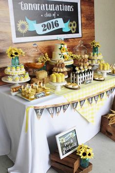 a table topped with cakes and desserts next to a chalkboard sign that says congratulations