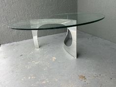 a glass table sitting on top of a cement floor