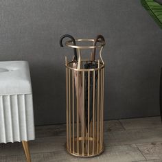 an umbrella stand next to a white chair and a potted plant on the floor