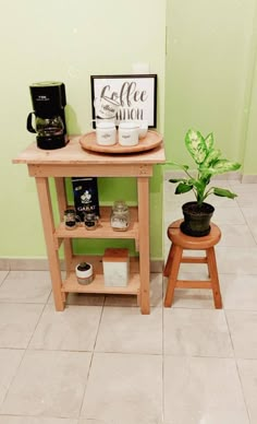 a small wooden table sitting next to a potted plant on top of a white tiled floor