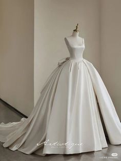 a white wedding dress on display in a room