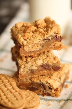 three cookies and two bars stacked on top of each other next to a glass of milk