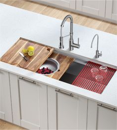 a kitchen sink with two cutting boards on the bottom and a cutting board in the middle