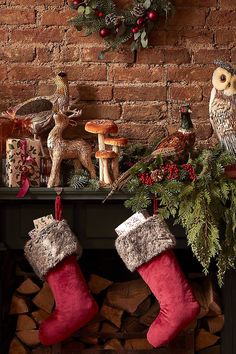 an owl sitting on top of a mantle next to christmas stockings and other holiday decorations