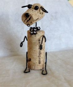 a wine cork sculpture with a dog on it's head sitting on top of a bottle