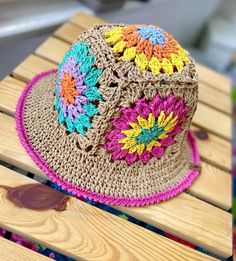 a crocheted hat sitting on top of a wooden bench