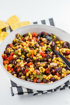 a white bowl filled with black beans and corn