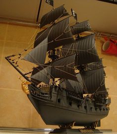 a model pirate ship is on display in a room with tile flooring and walls