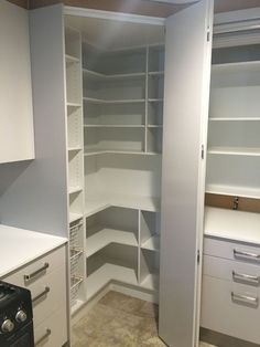 an empty pantry with white cabinets and drawers