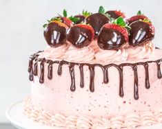 a strawberry cake with chocolate drizzle and strawberries on top