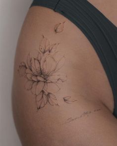 a woman's stomach with a flower tattoo on her left side ribcage