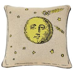 a yellow pillow with an image of the moon and stars in the sky on it