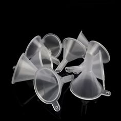 five plastic cups with spoons in them on a black background