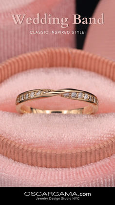 a wedding band with diamonds in it sitting on a pink velvet ring cushioned box