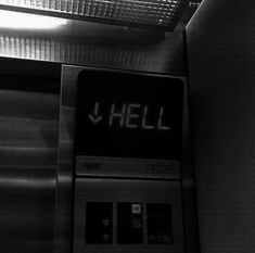 a black and white photo of a sign that says hell on the side of a wall