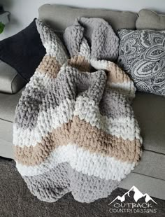 a knitted blanket sitting on top of a couch