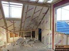 an unfinished room that is under construction with woodwork on the floor and windows above it