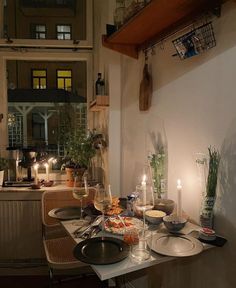 a dining room table is set with food and candles