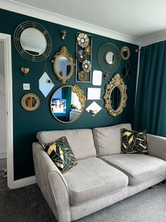 a living room filled with furniture and lots of mirrors on the wall above it's couch