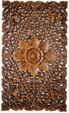 an intricately carved wooden panel with flowers and leaves on the center, is shown