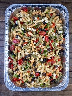 pasta salad with tomatoes, olives, and mozzarella in a baking pan