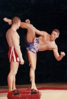 two men standing on top of each other in shorts