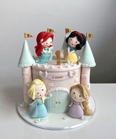 a cake that has some little princess figurines on it