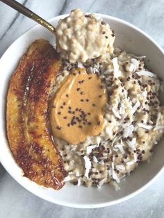 a bowl filled with bananas and rice covered in peanut butter