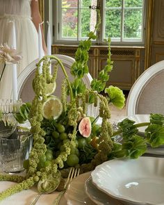 the table is set with plates, silverware and flowers