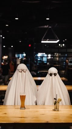 two ghost like figures sitting at a table