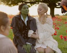 two people sitting in a field with flowers